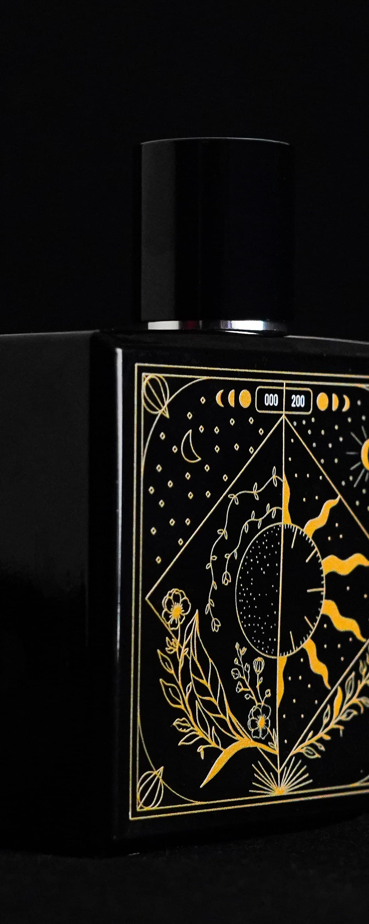 TAKUMI GENSŌ — the bottle's celestial face: a crescent moon and sun held in one gold-line frame, constellation and botanicals below, the edition number in the moon-phase band